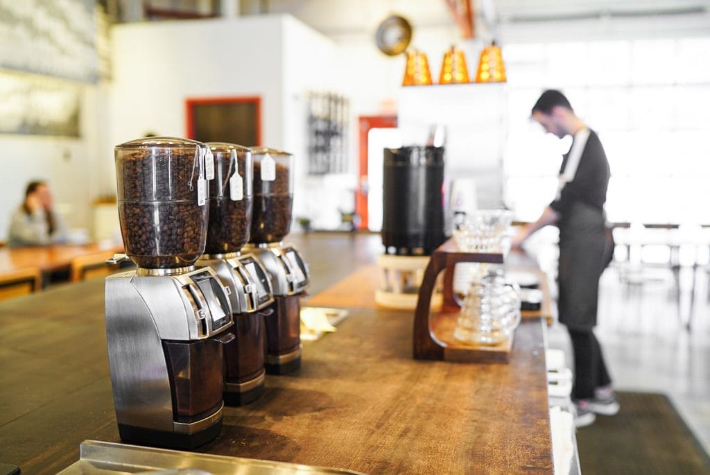 A café with several coffee grinders lined over the bar