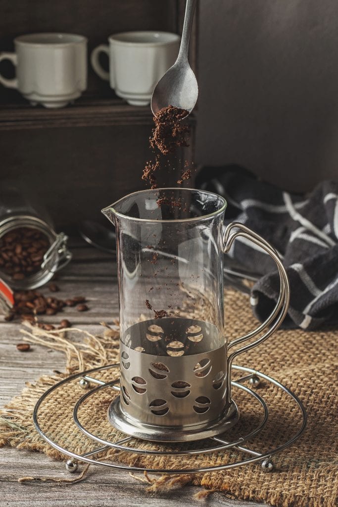 Adding ground coffee into the French press