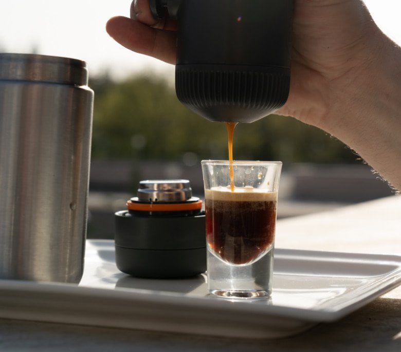 best portable espresso maker a picture of someone pulling an espresso with a portable espresso maker